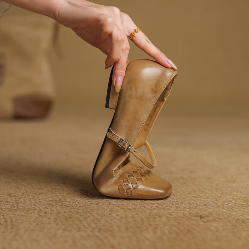 Tan Mary Jane shoe with square toe and ankle strap held in hand