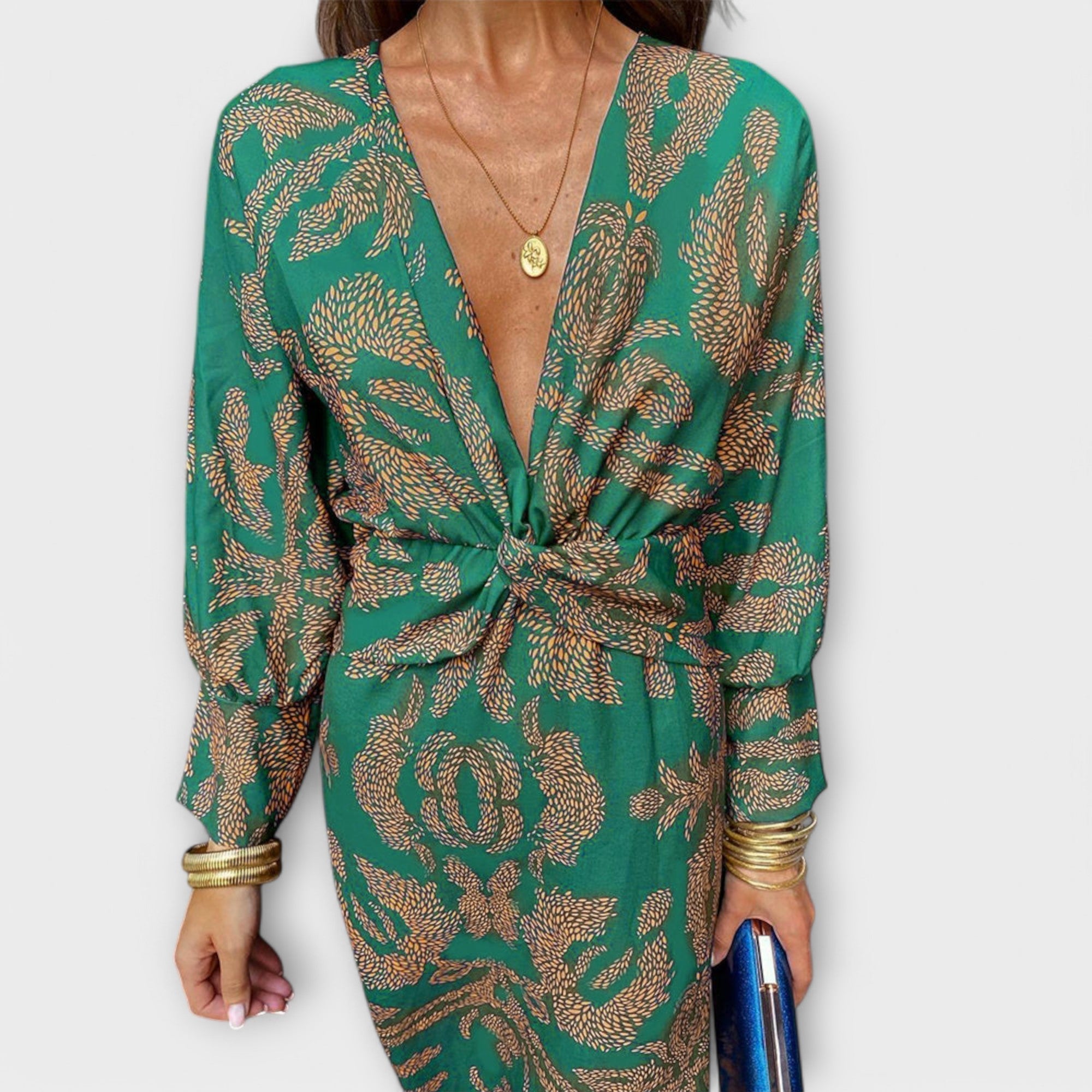 Elegant long-sleeve V-neck dress in green and gold ornate print, front knotted waist