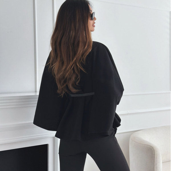 Women's black jacket back view with flared sleeves and belt at waist