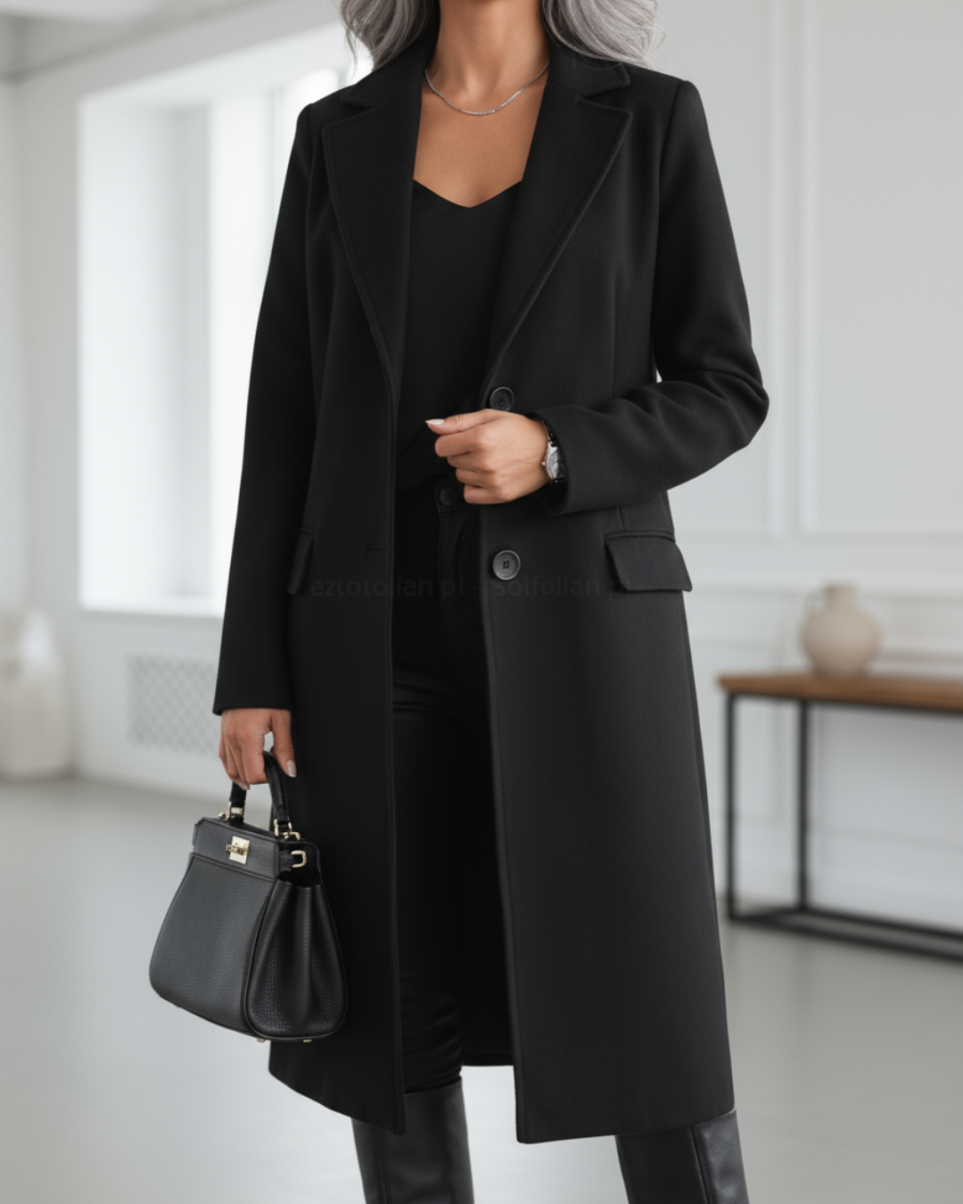 Women’s black long tailored coat with notched lapels, front buttons, and side pockets