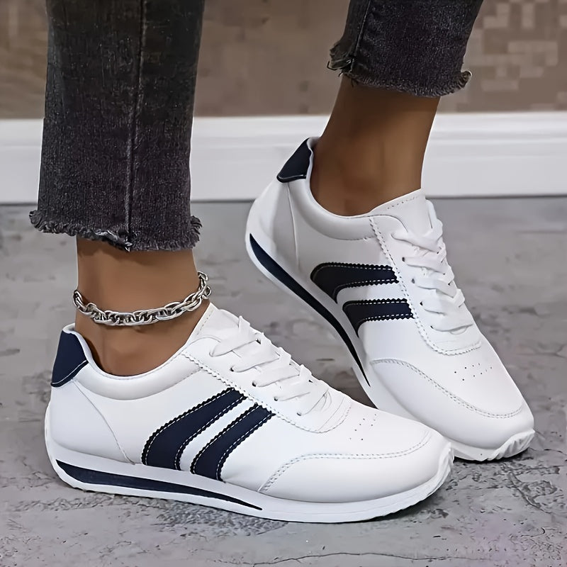 Pair of white lace-up orthopedic sneakers with navy accents and grippy outsole