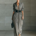 Long pleated grey dress with button front, belted waist, and three-quarter sleeves