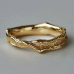 Hammered gold-tone band ring with wavy, organic texture and raised edges