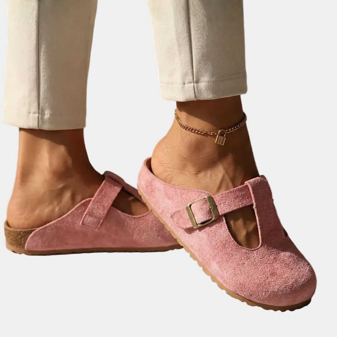 Pink suede slide clogs with square buckle strap and cutout instep