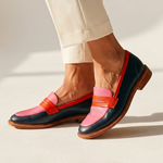 Color-block leather loafers with pink top, orange strap trim, and dark navy sides