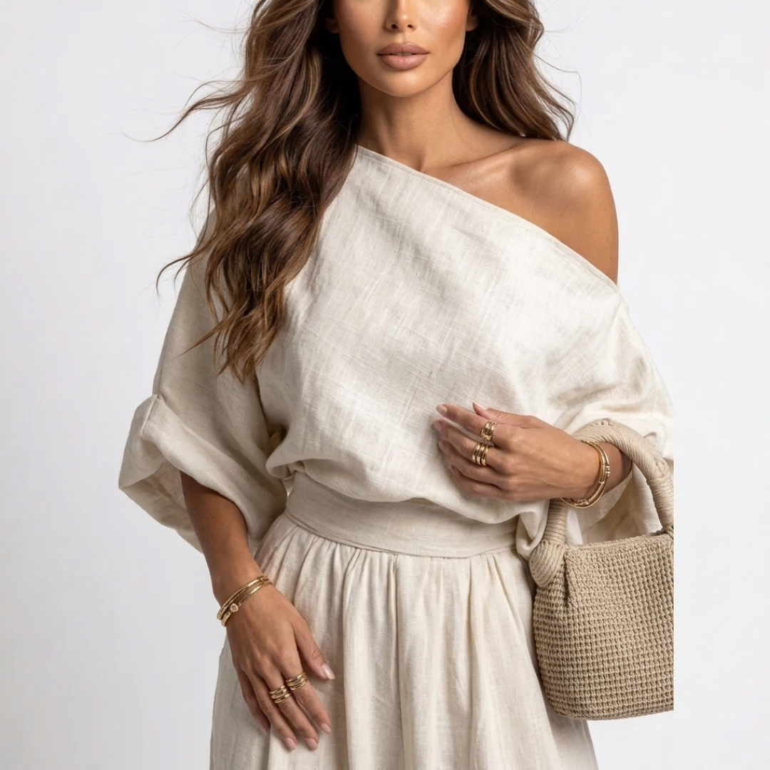 Off-white one-shoulder blouse with loose sleeves and elastic waist, with jogger pants