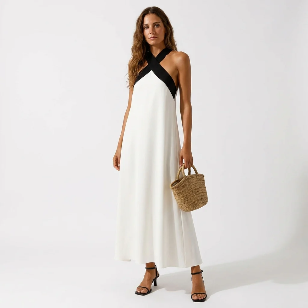 White cross-strap halter midi dress with black diagonal neckline strap and flowing skirt