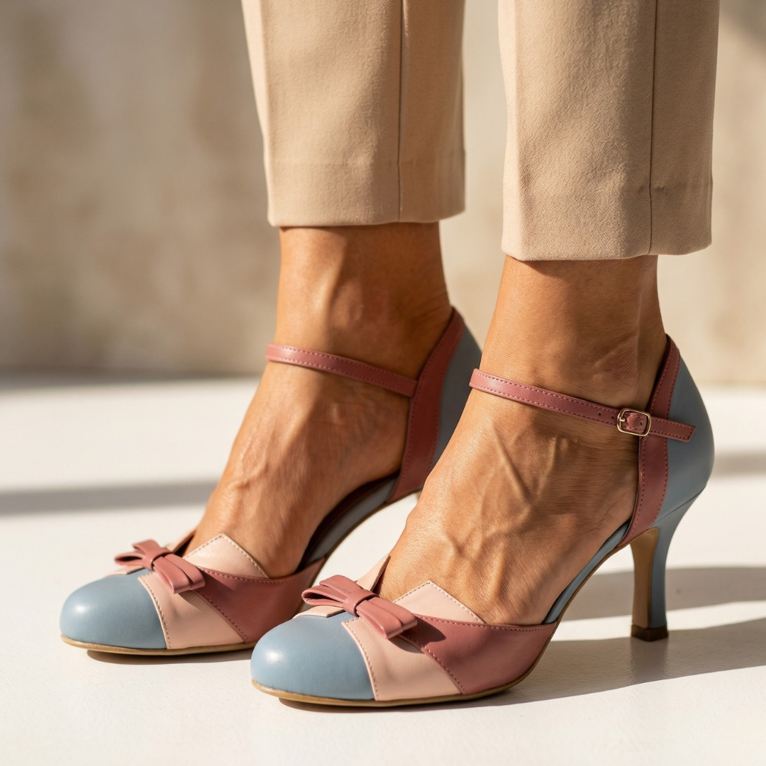 Pink leather heeled pumps with light-blue toe cap and ankle strap, bow detail