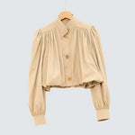 Cream short loose jacket with button front, pleated shoulders, and voluminous sleeves