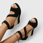 Black wedge sandals with ankle strap, open toe, and textured side platform
