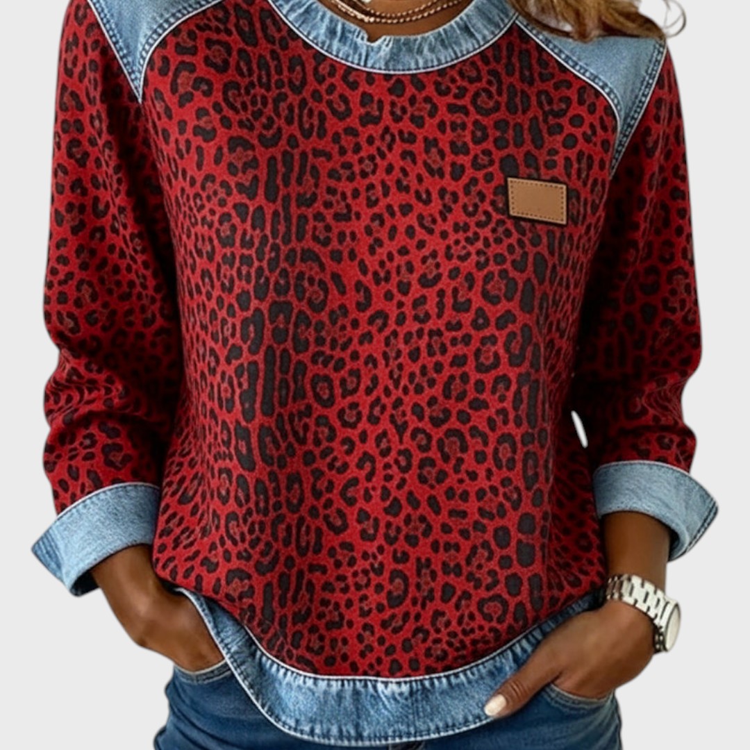 Red leopard print long-sleeve top with light denim collar and cuffs; tan chest patch