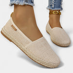 Beige espadrille-style slip-on loafers with fabric upper and braided platform sole