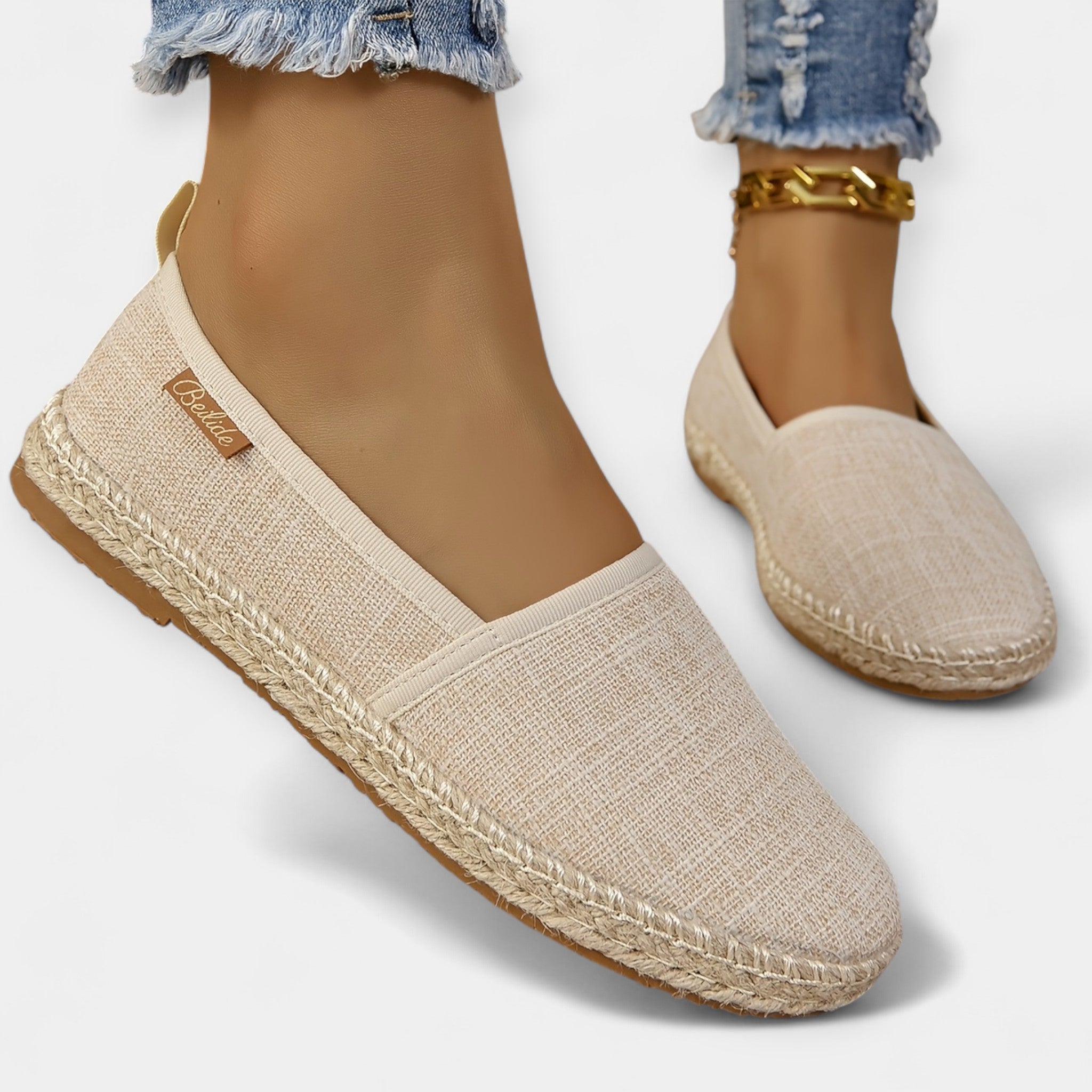 Beige espadrille-style slip-on loafers with fabric upper and braided platform sole