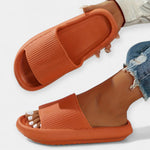 Orange slide sandals with wide textured strap and open toe