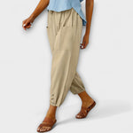 Beige harem pants with side pockets and button-tab cuffs, relaxed loose fit