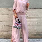 Two-piece chiffon set with short-sleeve blouse and wide-leg pants, soft blush pink.