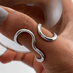 Silver-tone asymmetric wave statement ring with curled open-loop design