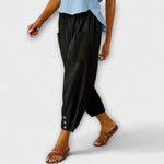 Black harem pants with side pockets and button-tab cuffs, relaxed loose fit