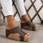Brown heeled wedge sandal with open toe, studded cross strap and cork sole