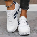 White orthopedic sneakers with navy side stripes, front view, cushioned textured sole