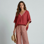 Women's rust red V-neck top with striped wide-leg pants and contrast trim
