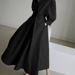 Black long wrap-style dress with puff sleeves and tied waist, swaying full skirt