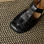 Black natural leather sandal close-up with stitched straps and buckle fastening