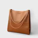 Caramel natural leather tote bag with curved strap handles and front tab detail
