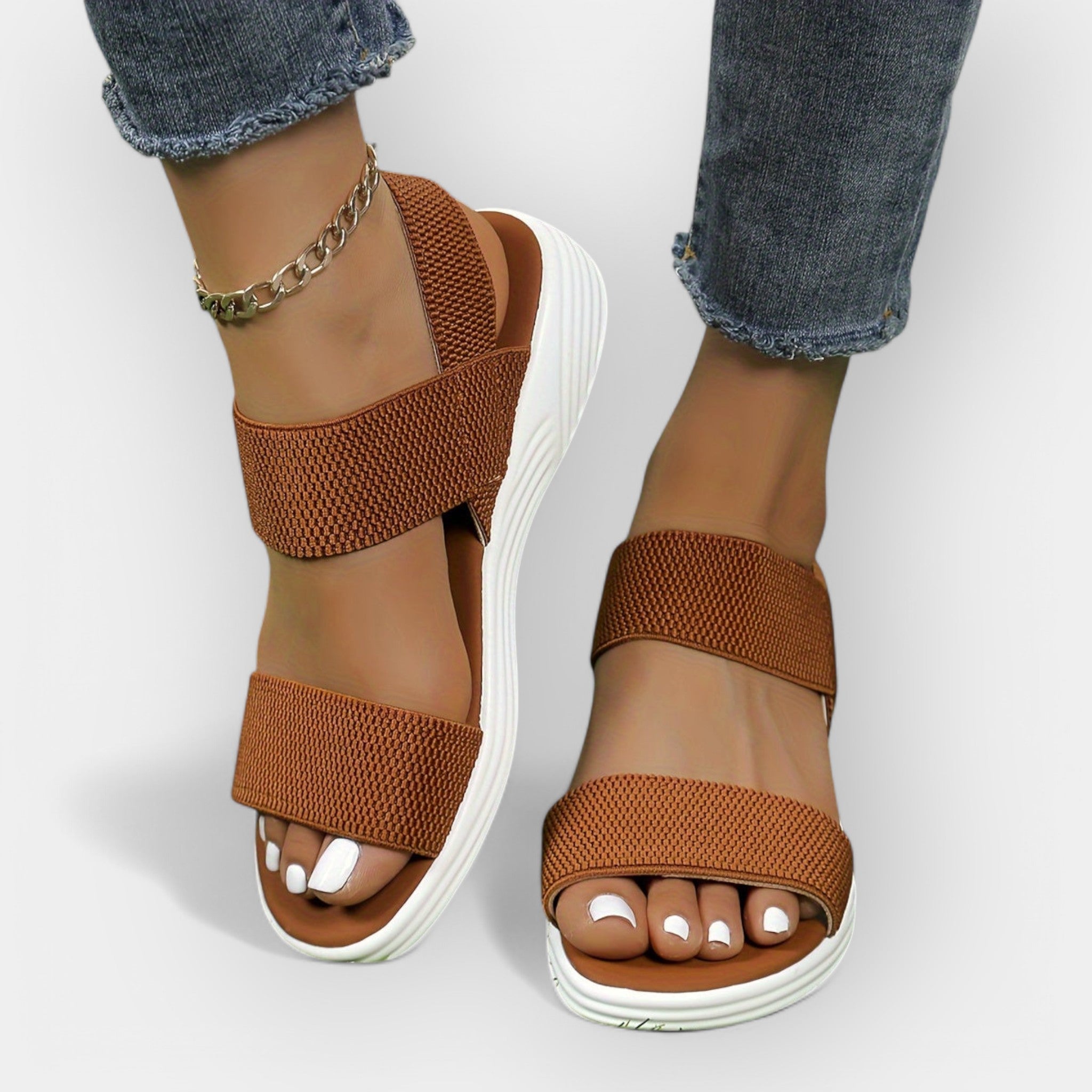 Comfort sandals with wide textured straps, open toe, brown upper, white platform sole.