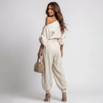Off-white one-shoulder top with wide sleeves and matching relaxed harem pants