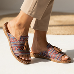 Platform slide sandals with multicolor zigzag fabric straps, open toe, tan stitched sole, tassel
