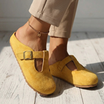 Yellow suede slide clogs with square buckle strap and cutout instep