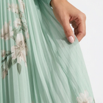 Mint green pleated fabric with soft floral print detail on a midi dress