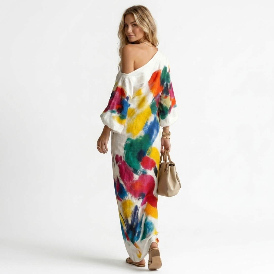 One-shoulder maxi dress side view, white with bold multicolor abstract print and 3/4 sleeves