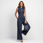 Carmen sleeveless pinstripe jumpsuit holding a navy shoulder bag, wide-leg fit