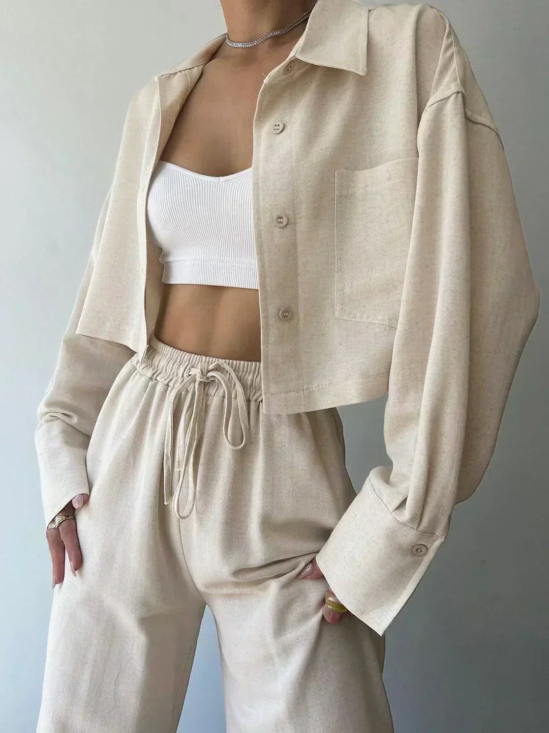 Light beige two-piece pants set with collared button-up top and drawstring trousers