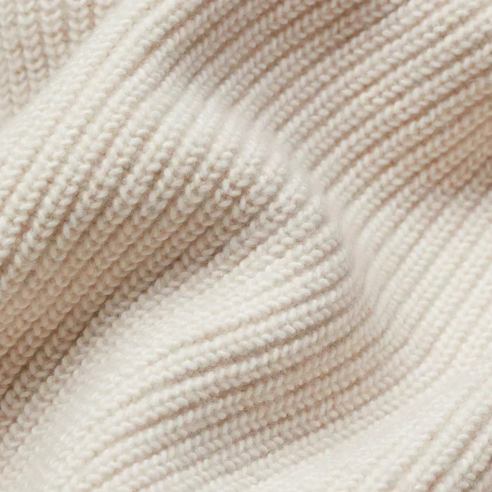 Cream textured knit cardigan fabric close-up with ribbed pattern