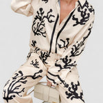 Silk pajama set in cream and black coral print, button-front long-sleeve top and pants