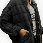 Black roomy quilted puffer jacket, full-zip front, side pockets.