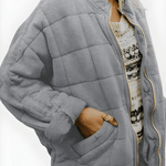 Gray quilted puffer jacket with full-zip front and side pockets, stand collar.