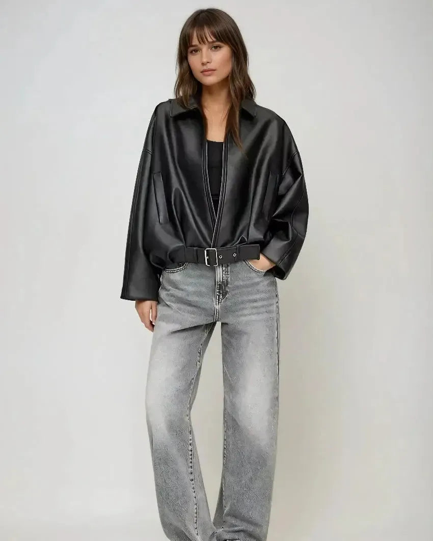 Black zip-front oversized jacket with collar and belted waist, worn with light jeans