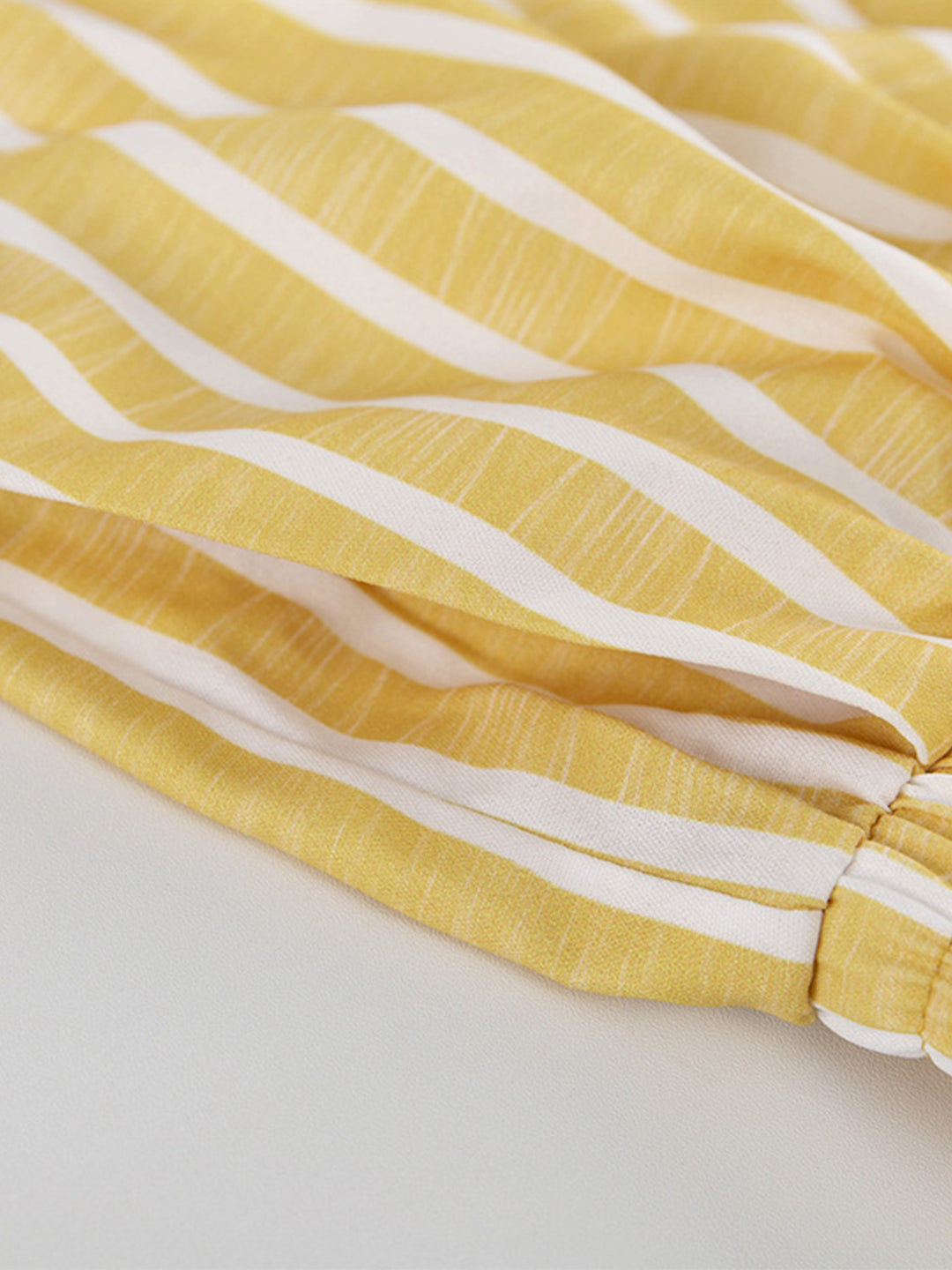 Yellow and white striped fabric panel, seam and stitched edge