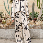 Silk pajama set with cream-and-black coral print, long-sleeve shirt and matching wide-leg pants
