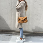 Long taupe knit cardigan draped over shoulders, open front with ribbed cuffs and hem.