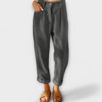 Cropped gray pants with pleats, button fly, and side pockets