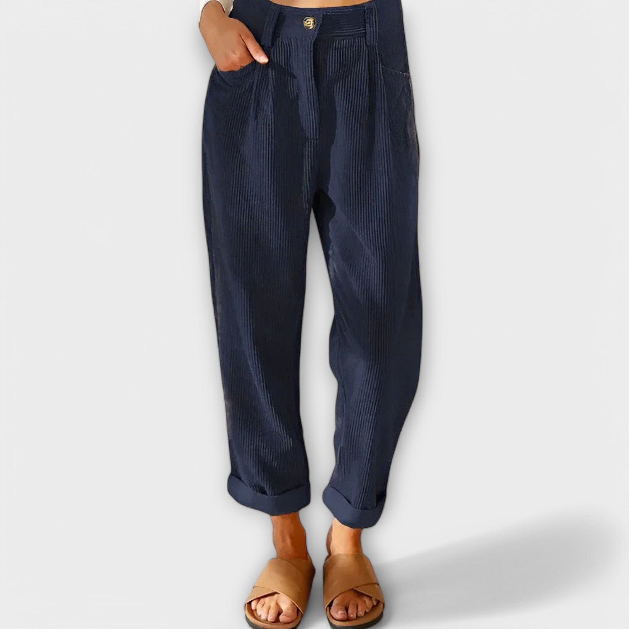 Cropped navy pants with pleats, button fly, and side pockets