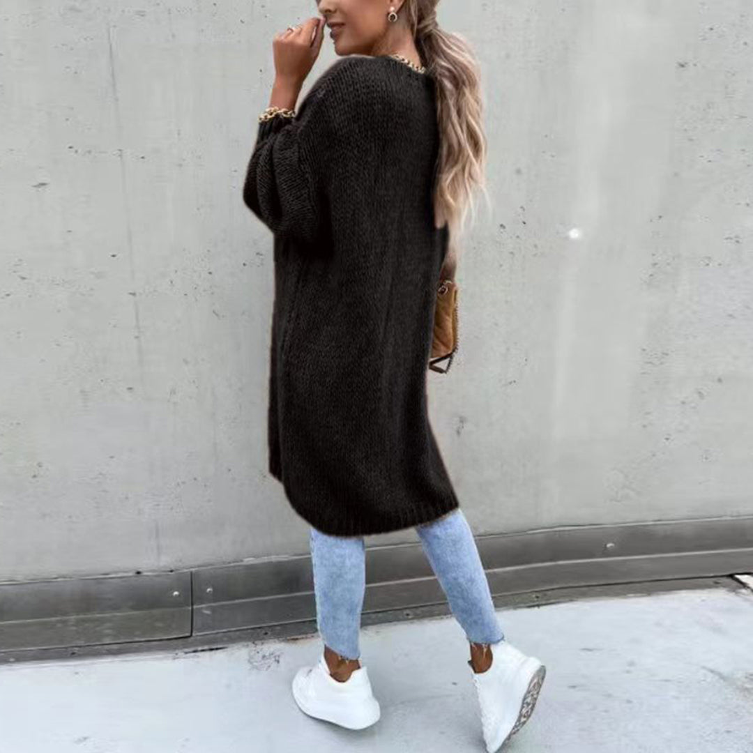 Long black knit cardigan, open front and ribbed cuffs, textured fabric with straight hem.
