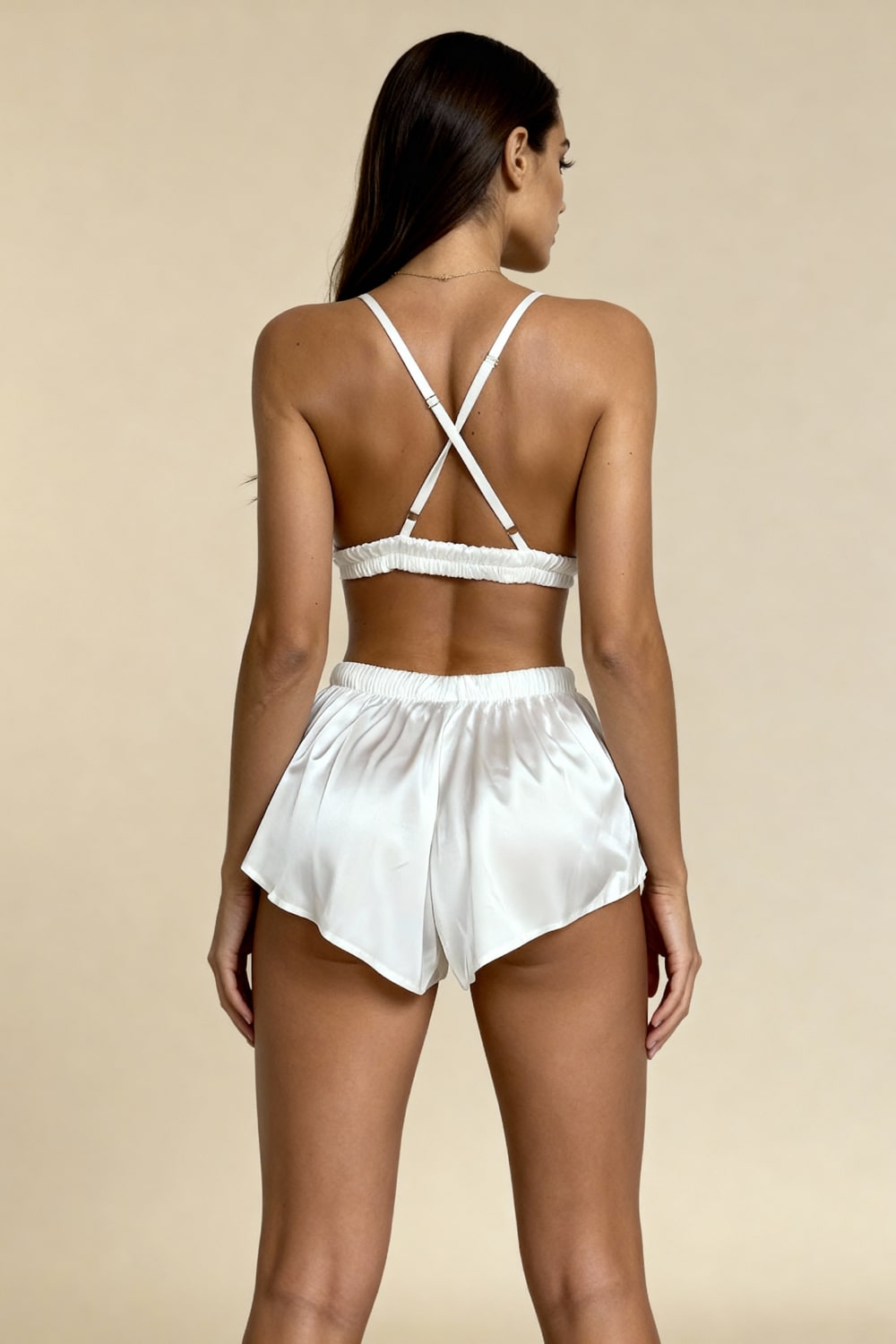 White satin backless pajama bra with crisscross straps and lace-trim shorts with tie waist