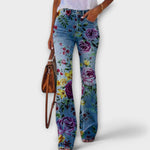 Floral print denim pants with bold purple roses and small colorful blooms on legs