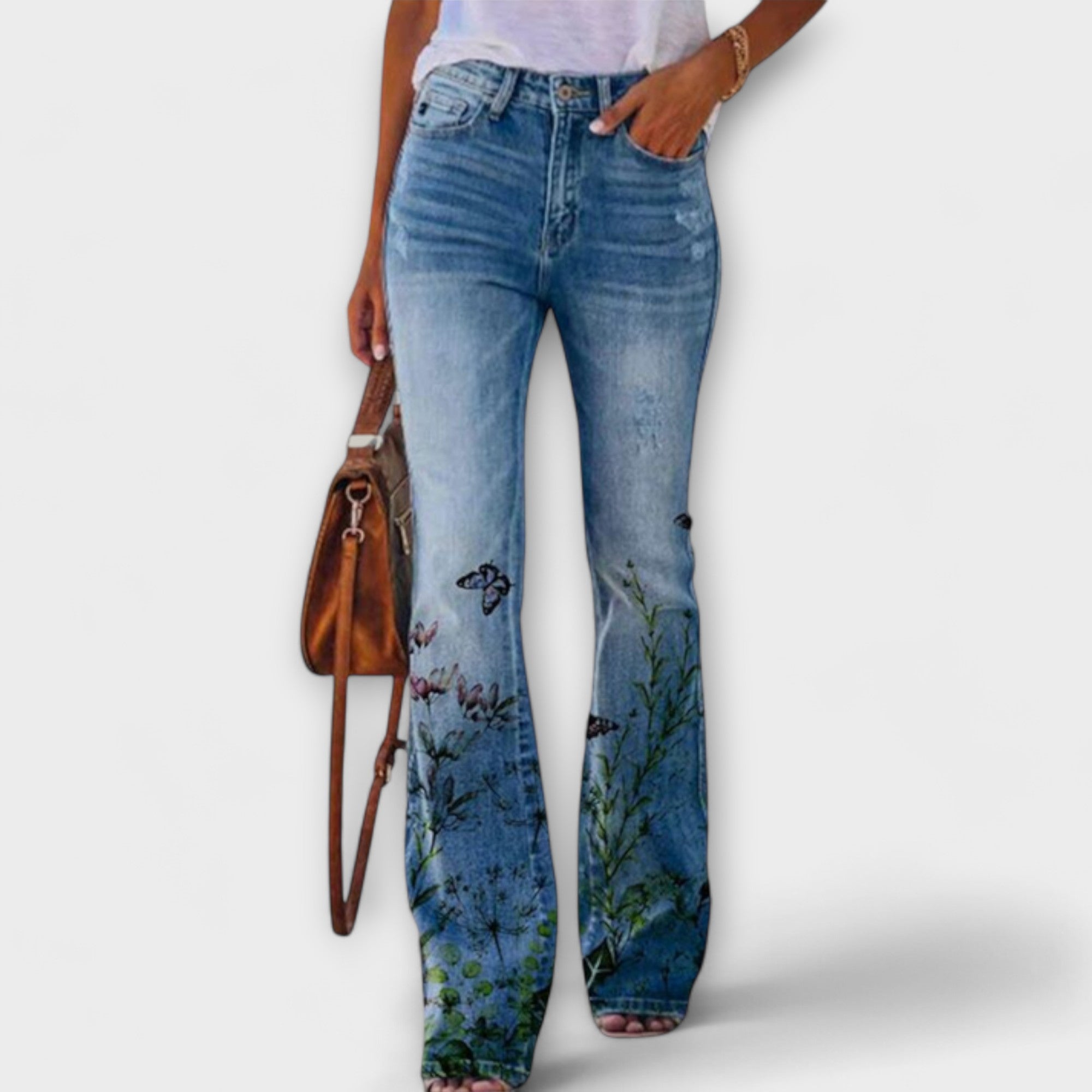 Floral print denim pants with black butterfly and blue-green botanical graphics